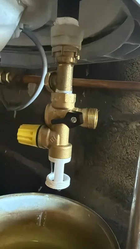 Groupe de sécurité de chauffe-eau vidangé dans une bassine